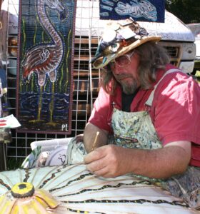 Peter Loose of Hull, Ga. adds details to snakes he painted on a parasol.