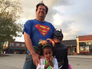 David James and his children Tehilla and David take in the sights and the candy during Trick or Treat on the Clarkesville Square.