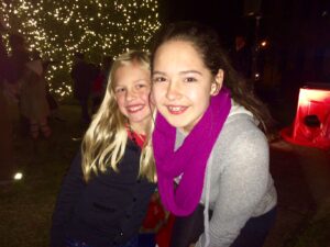 8-year old Ava Fowler of Clarkesville shares candy canes and hugs with 14-year old Catie Long of Cornelia.