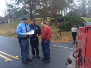 Truck driver Jason Moore (center) talks with GSP Trooper Sanders.