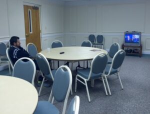 Jose Garcia-Flores watches the news in the fellowship hall at First Baptist Church of Cornelia.