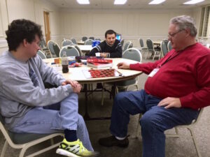 Shelter manager Bobby Tyler, right, plays checkers during the last shelter opening in January 2015 as accused killer Jose Garcia Flores, center, looks on. Know one knew at the time he was an alleged criminal. Garcia-Flores turned up at the shelter without ID. Policies have since changed requiring IDs and background checks.