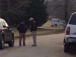 Officers guard the crime scene as GBI investigators search for evidence inside. 