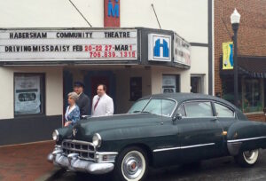 The cast of Driving Miss Daisy pose by the original Cadillac used in the 1989 screen adaptation of the play starring Jessica Tandy and Morgan Freeman. Pictured are: Alta Moseley as Daisy Werthan, Bruce Martin as Hoke Colburn and Justin Dudkiewicz as Boolie Werthan.