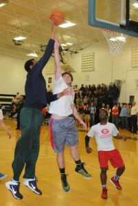 TFS senior Eli Keene of Demorest stretches to block a shot by TFS assistant athletic director and coach Lowell Hamilton. Also shown is senior Emmanuel Cureton of Timberlake, N.C.