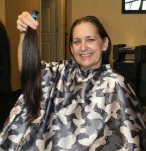 Ruby Brock displays her length of hair to be donated.