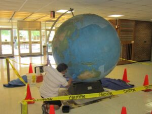 Here artists are seen painstakingly restoring the iconic globe.